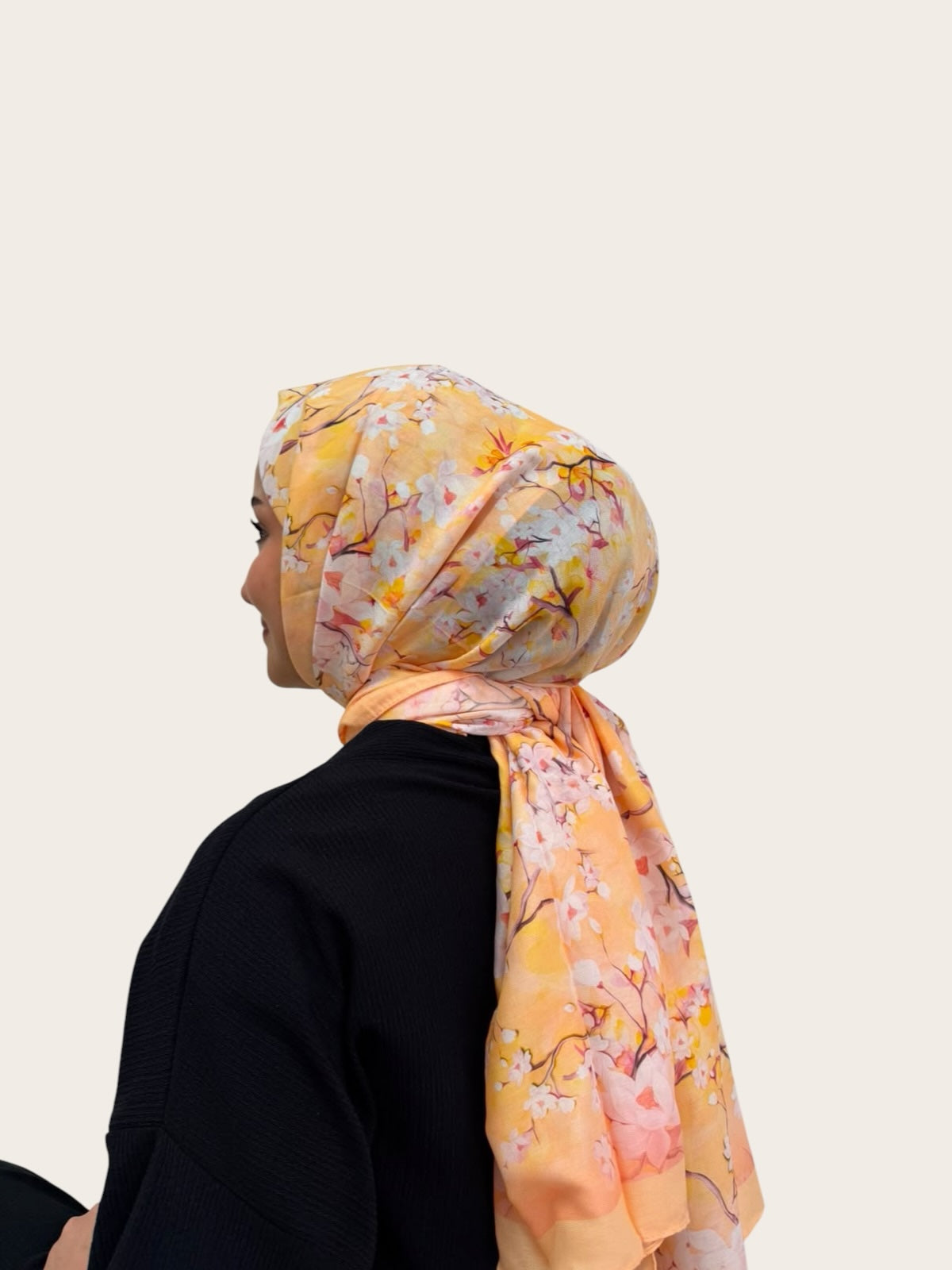 Loressina marka sarı ve turuncu tonlarında çiçek desenli, ipek dokulu, yandan görünüşlü zarif kadın şal modeli.