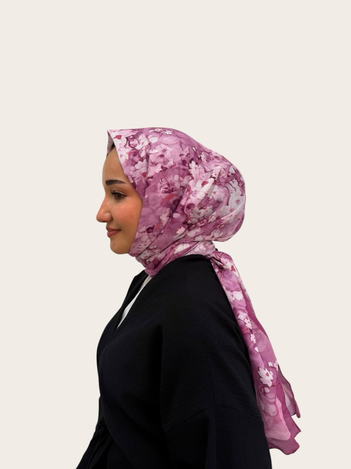Loressina marka, mor ve lila tonlarında çiçek desenli, zarif ipek şal takmış yandan görünüşlü kadın modeli.