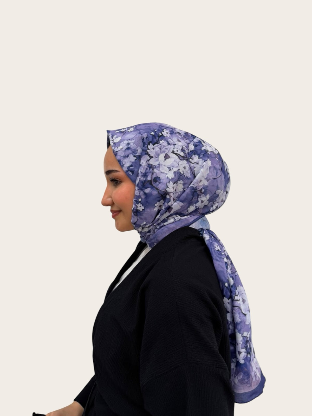 loressina marka, beyaz çiçek desenli, mor tonlarında zarif ipek şal takmış yandan görünüşlü kadın modeli