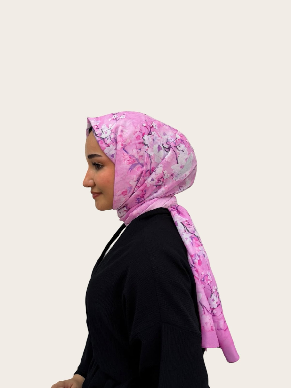 loressina pembe çiçek desenli, beyaz ve mor detaylı, hafif dokulu günlük şal takan bir kadın profili
